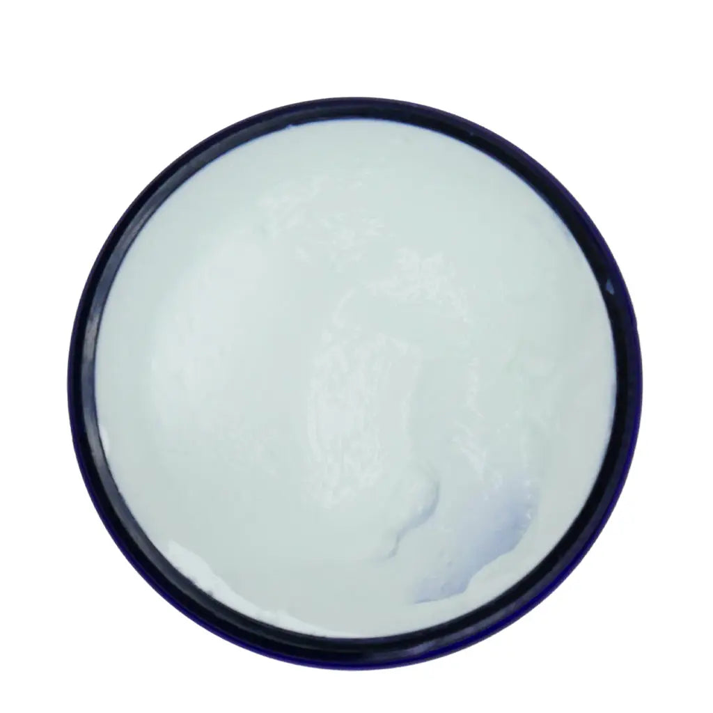 Round container with white cream on a white background