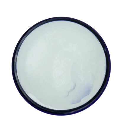 Round container with white cream on a white background
